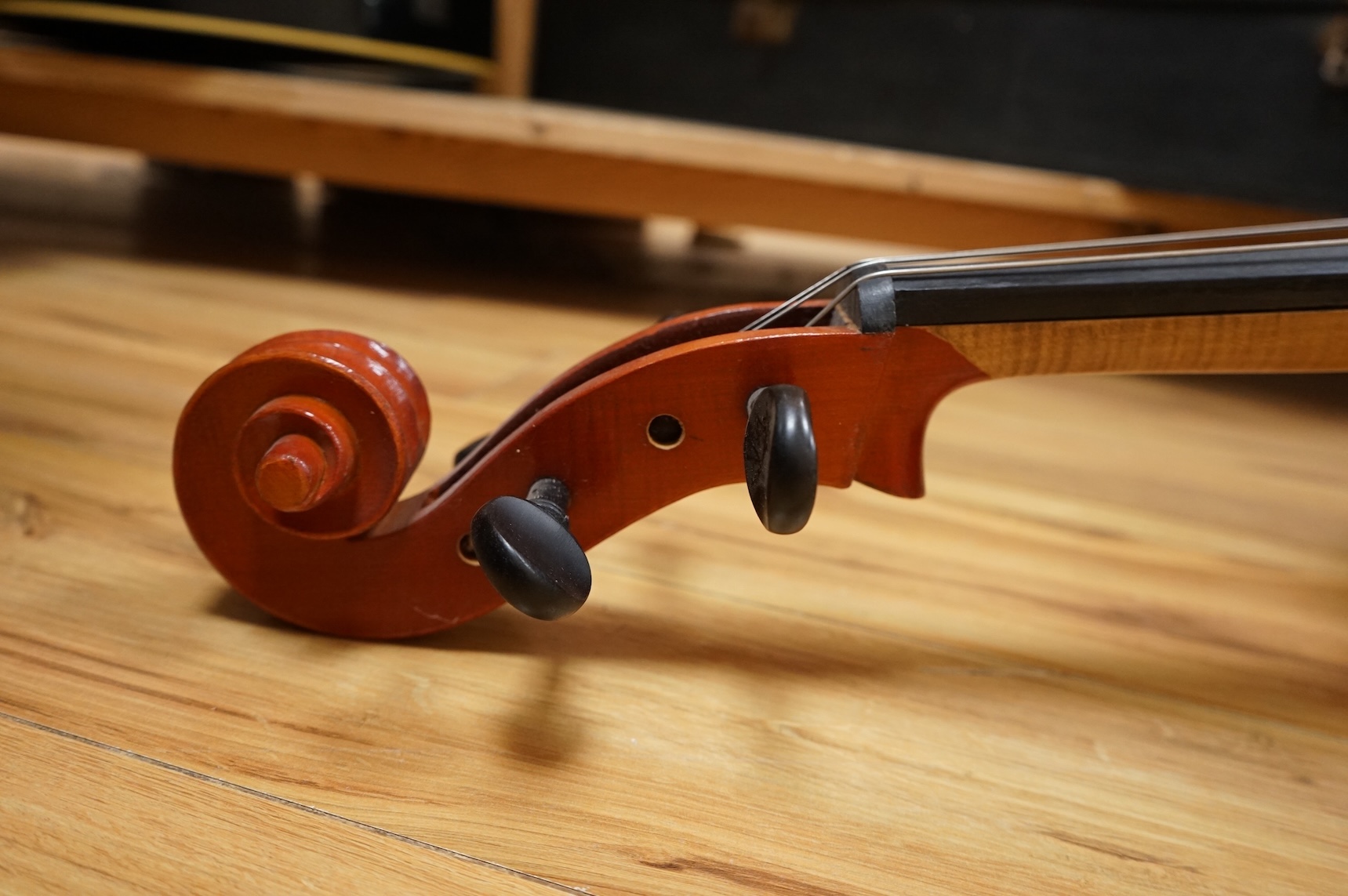 A modern student’s cello in a soft case and a student’s Spanish classical guitar